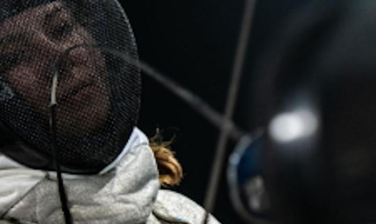 Scherma: atleta in azione con maschera e spada.