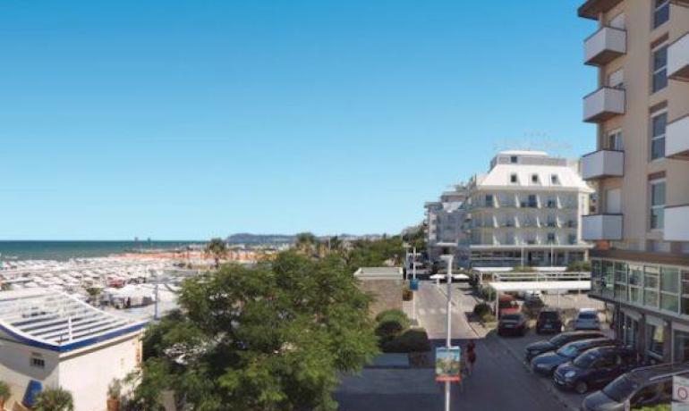 Vista su strada e spiaggia con edifici moderni.