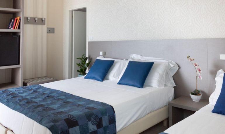 Camera moderna con letto matrimoniale e decorazioni blu.