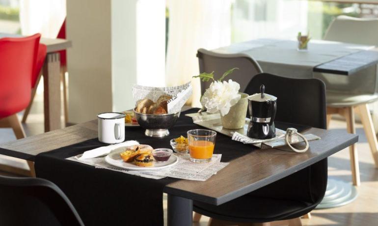 Colazione elegante con caffè, succo e pane in una sala luminosa.