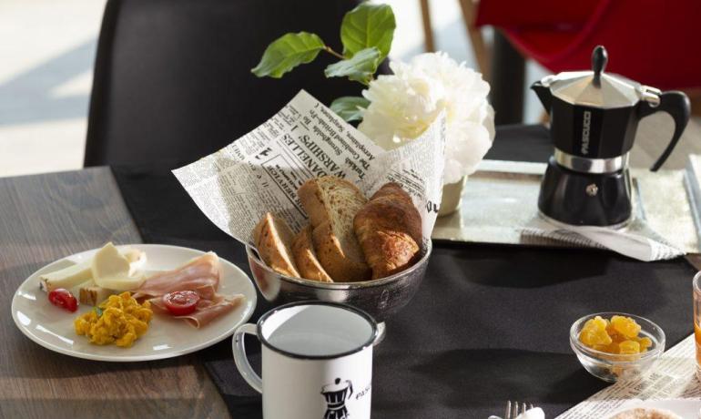 Colazione con pane, formaggio, uova e caffè.