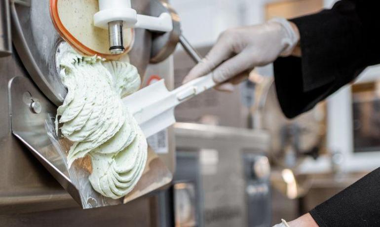 Preparazione di gelato artigianale in laboratorio con macchina professionale.